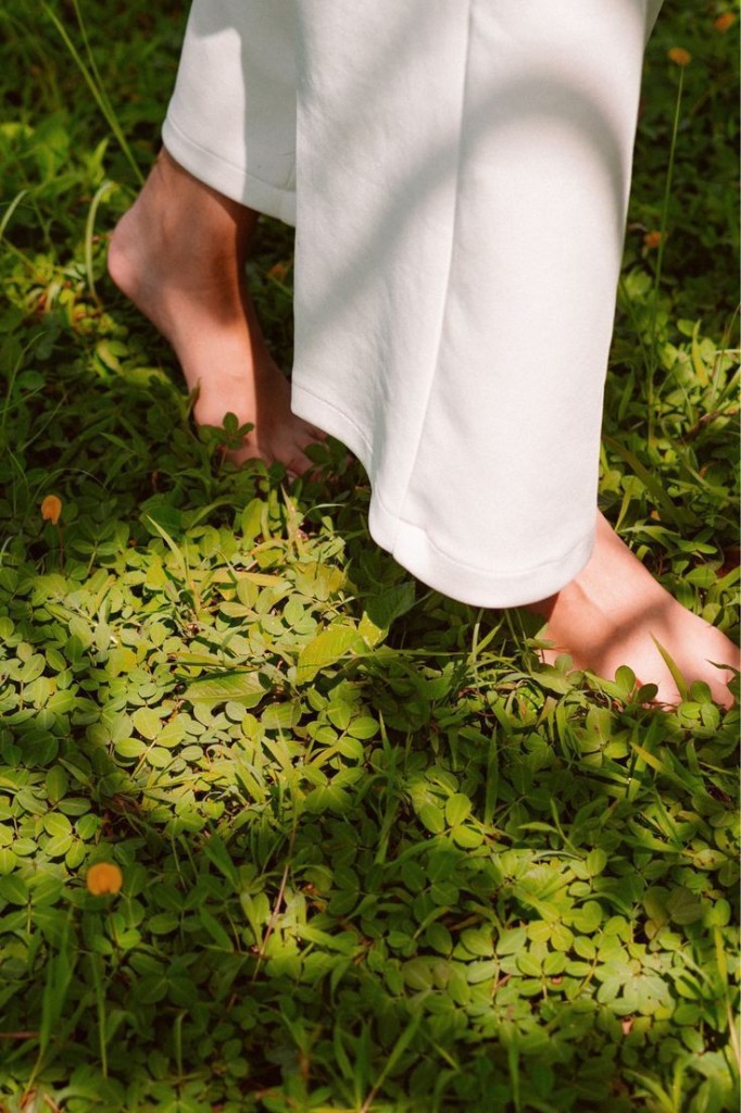 Fashion — barefoot walk through green grass